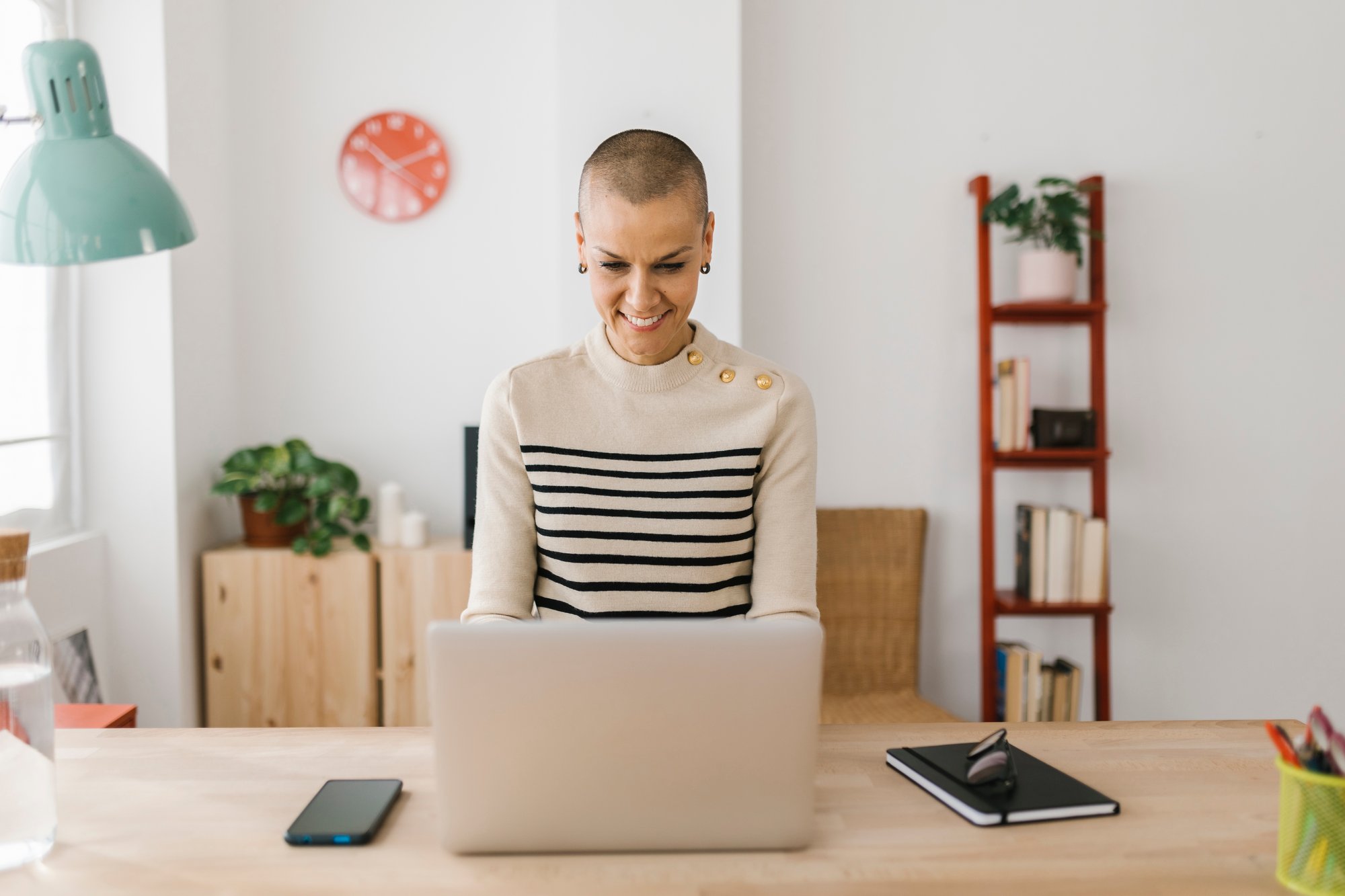 smiling-mid-adult-woman-using-laptop-at-home-offic-2023-11-27-05-35-26-utc